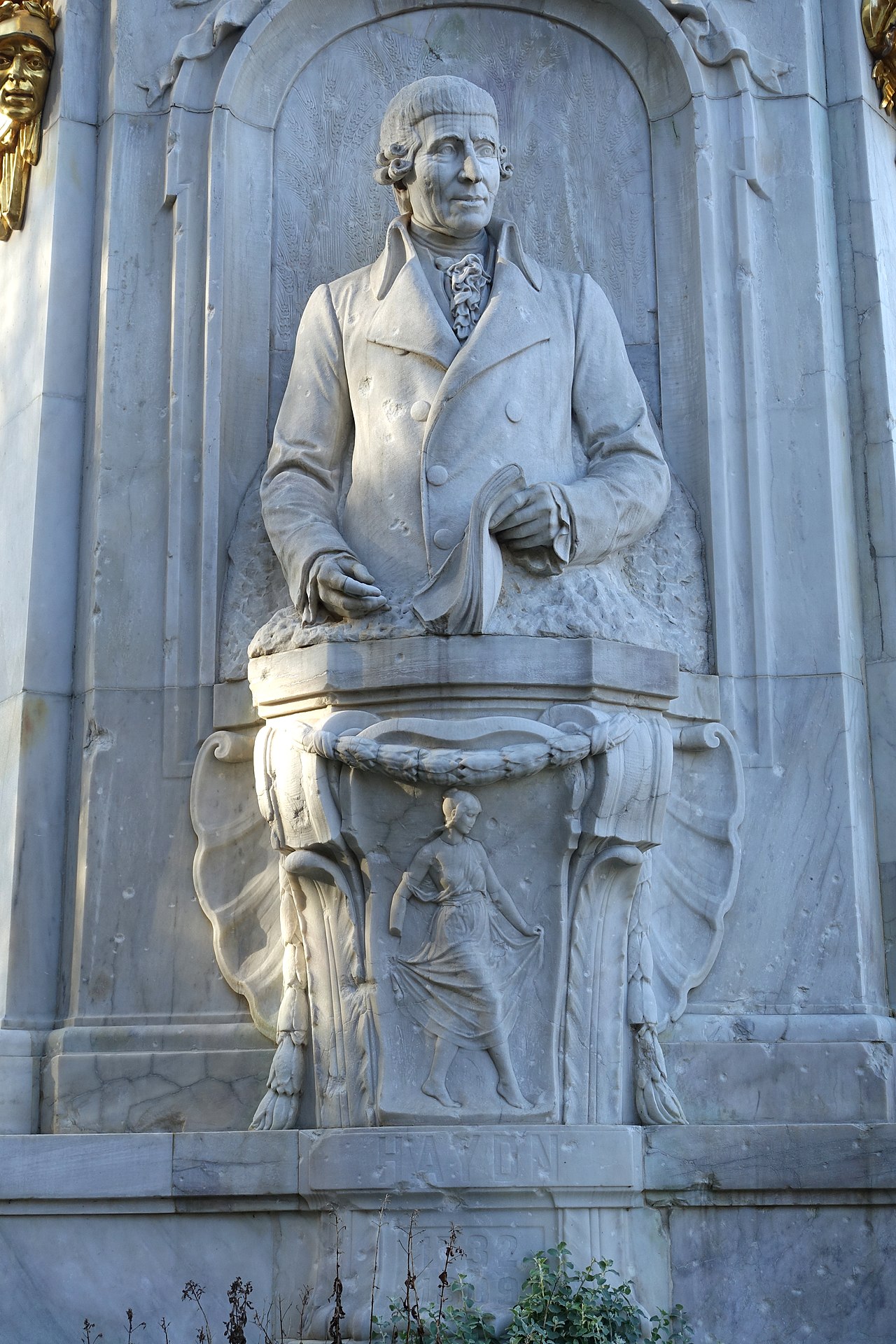 A stone statue honoring three famous classical music composers in Berlin.