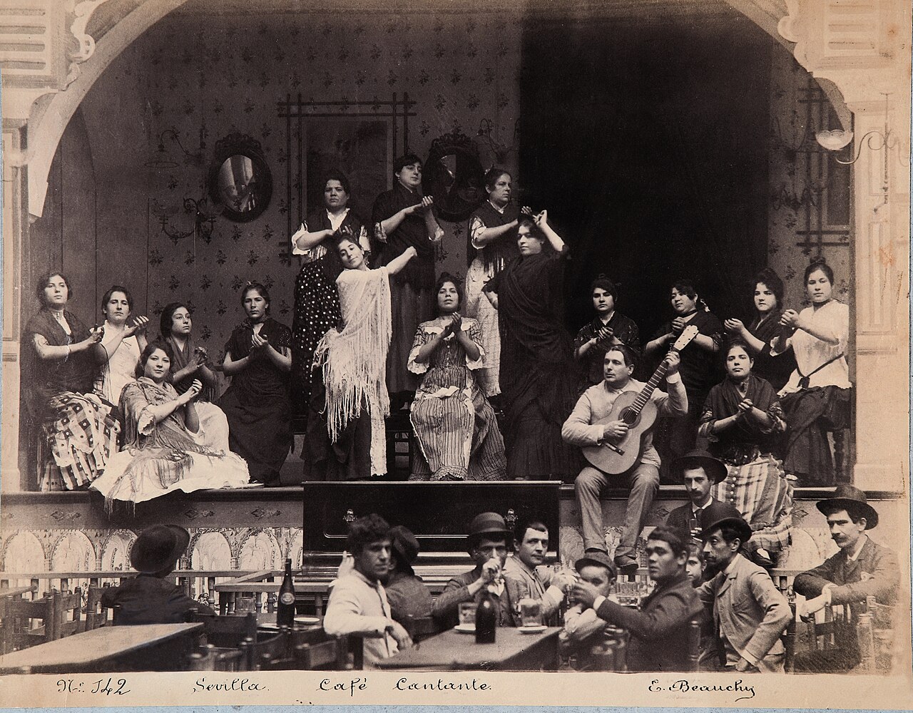 An old photo of flamenco dancers and musicians in a Spanish cafe.