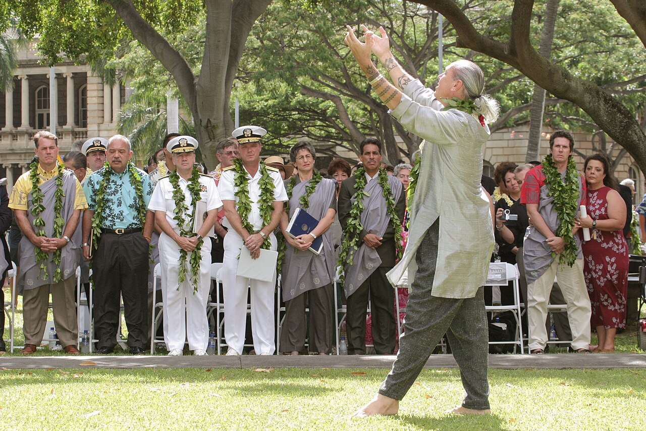 A hula dancer performing a graceful Hawaiian dance at a ceremony.