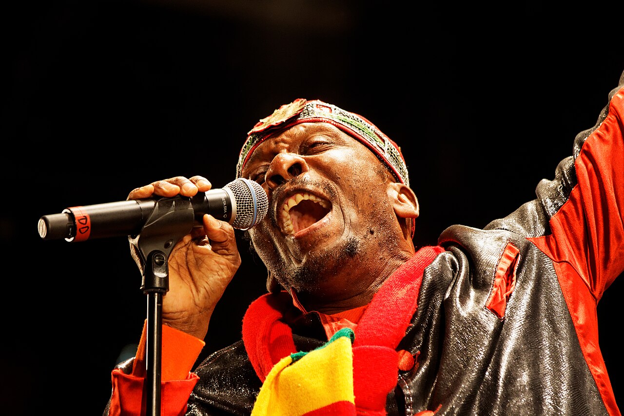 A reggae singer performing live for a crowd at a music festival.