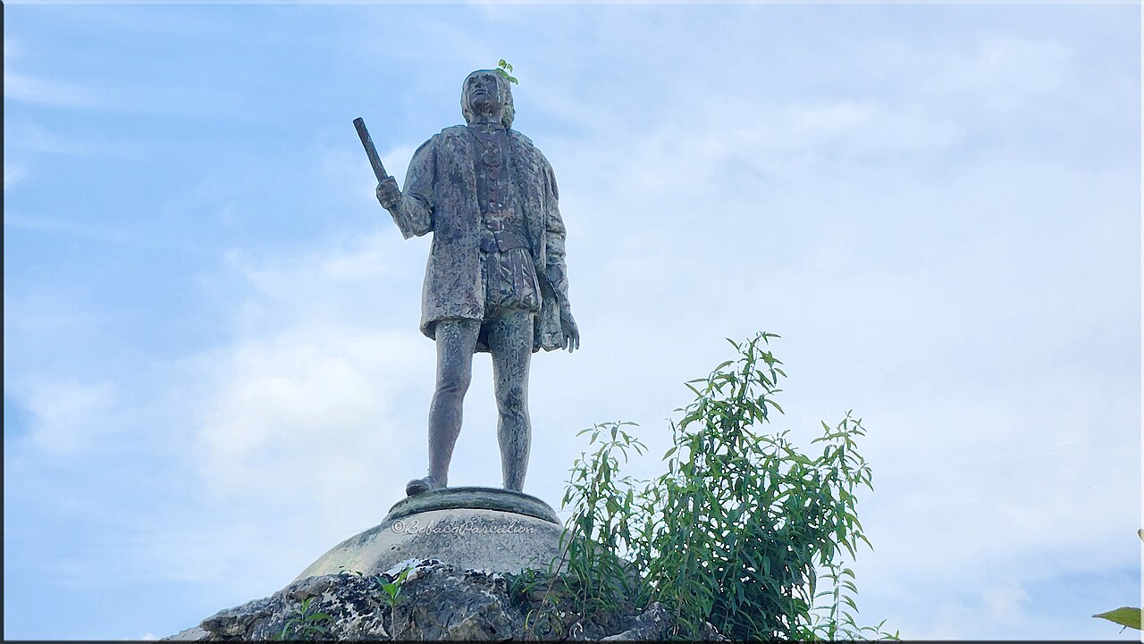 Statue of Christopher Columbus holding a scroll in Jamaica.