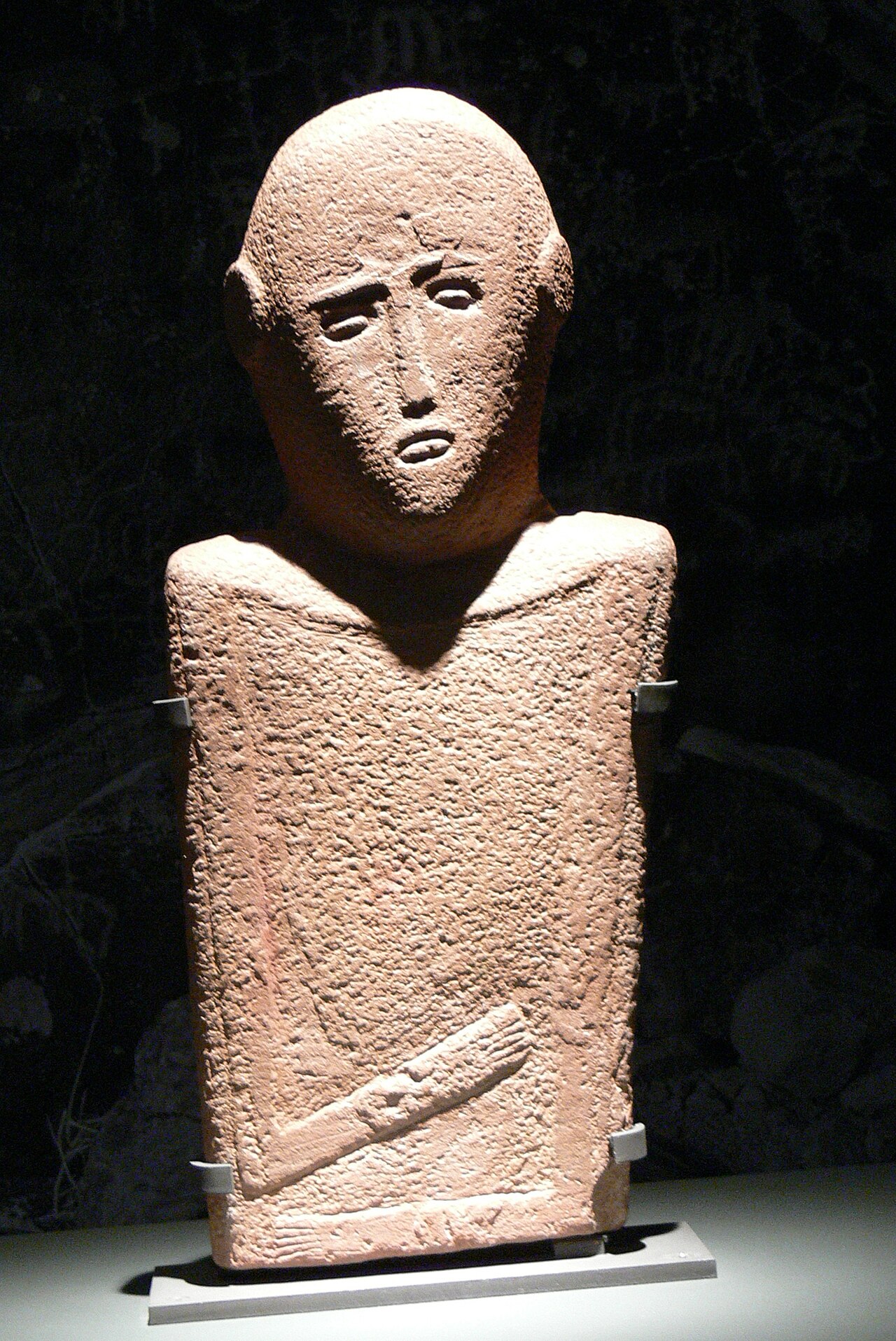 Tall carved stone shaped like a person from long ago.