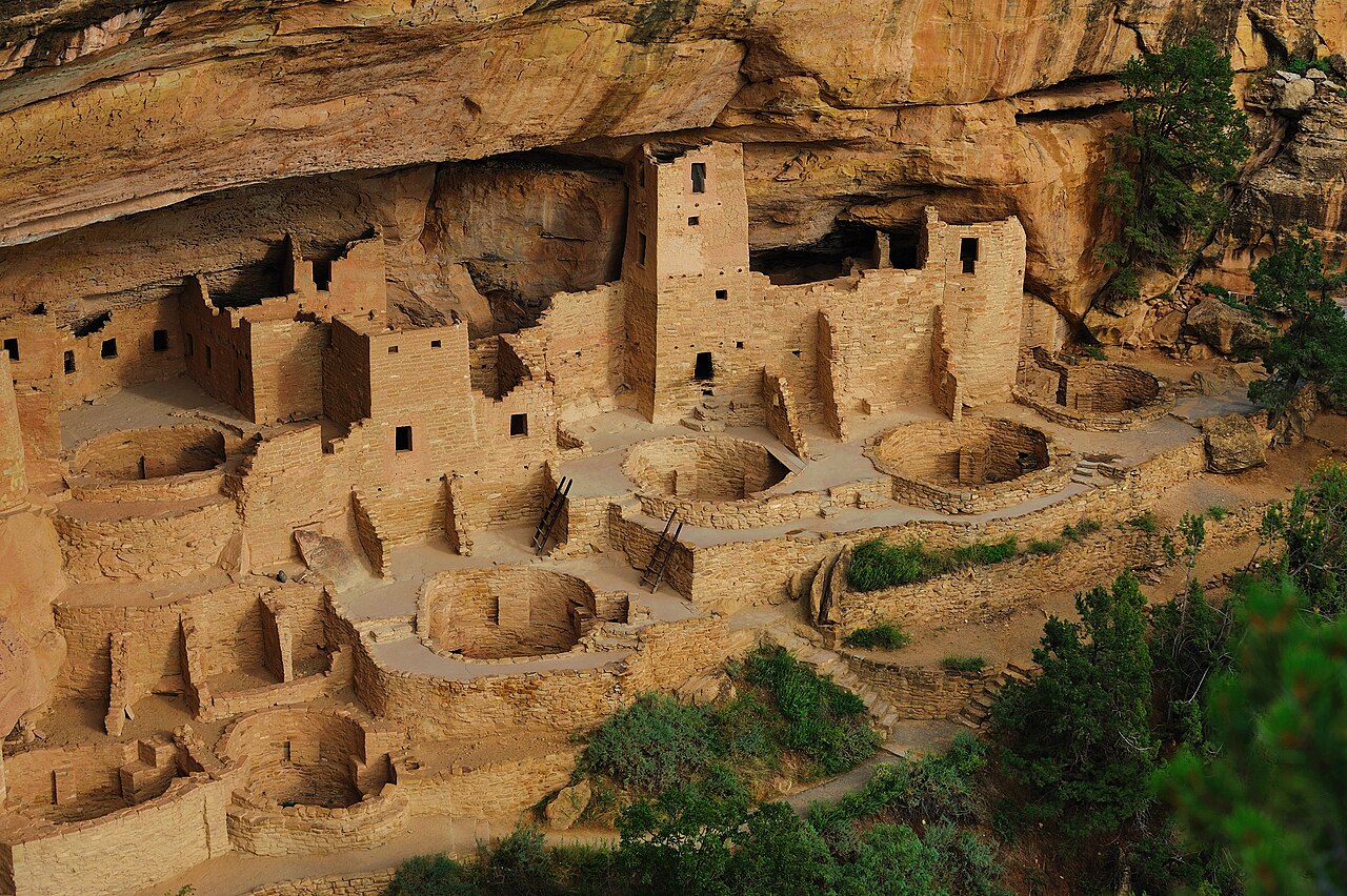 Ancient cliff homes built into a tall rock wall.