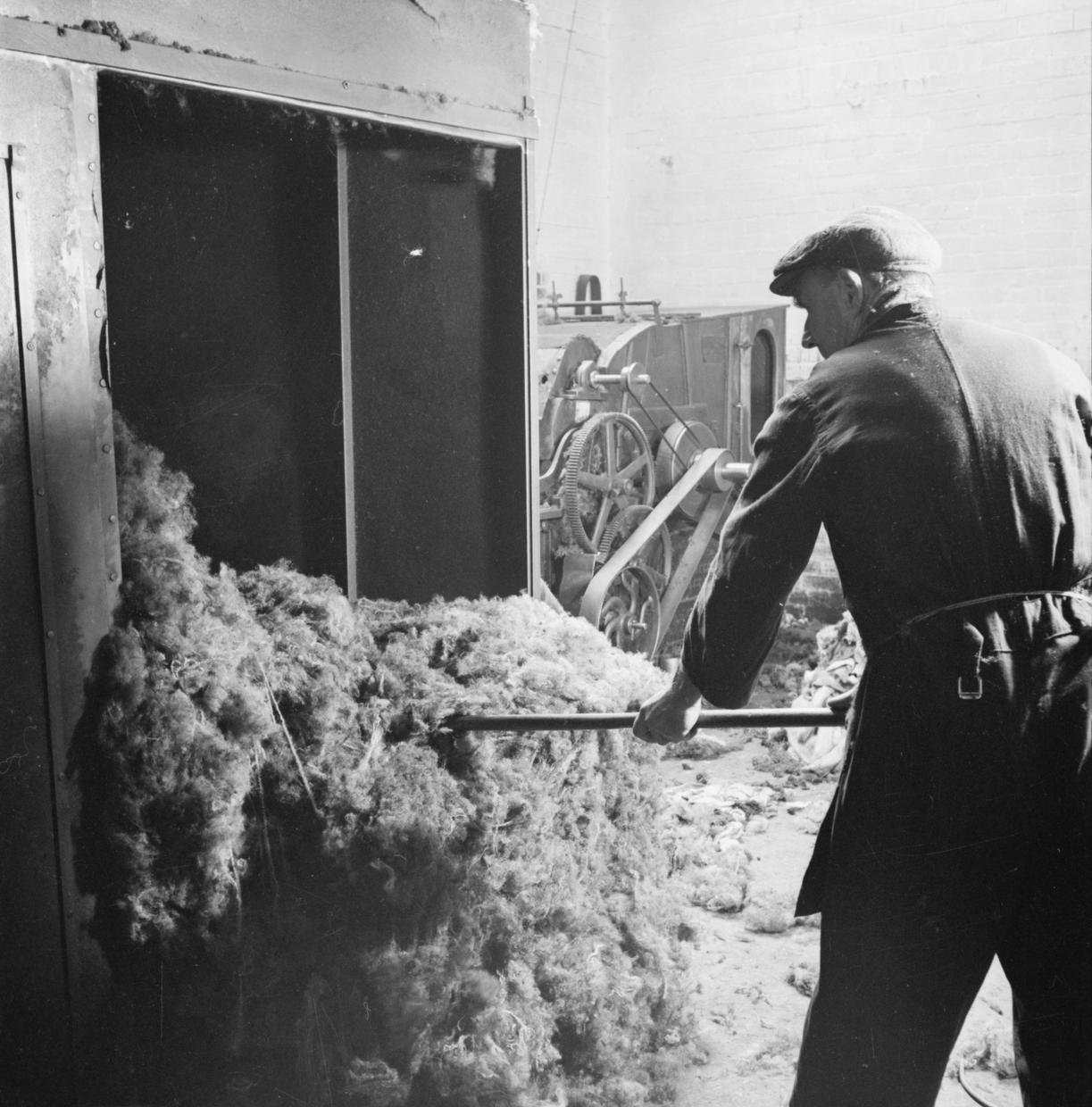A worker turns old rags into soft fluff to make brand new cloth.