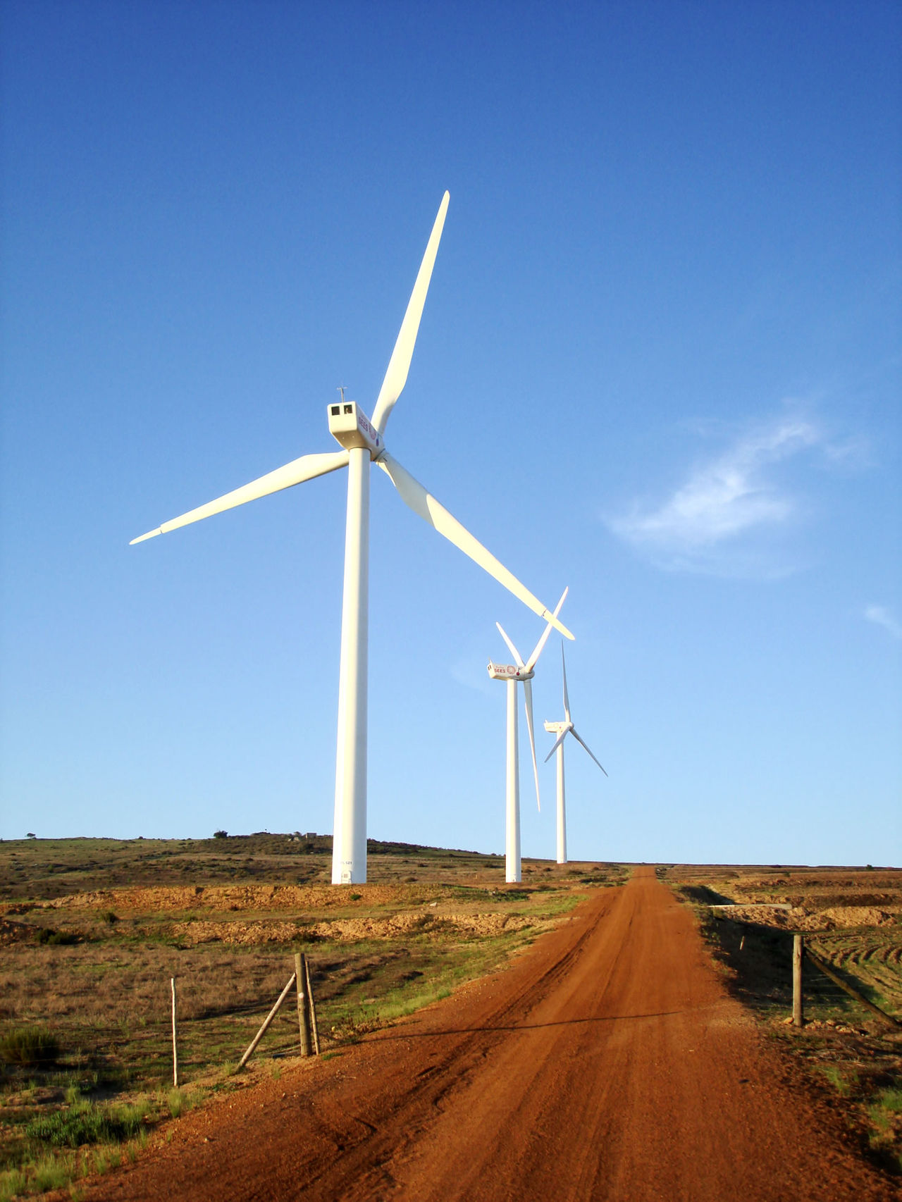 Tall wind turbines spin to make clean power for homes.