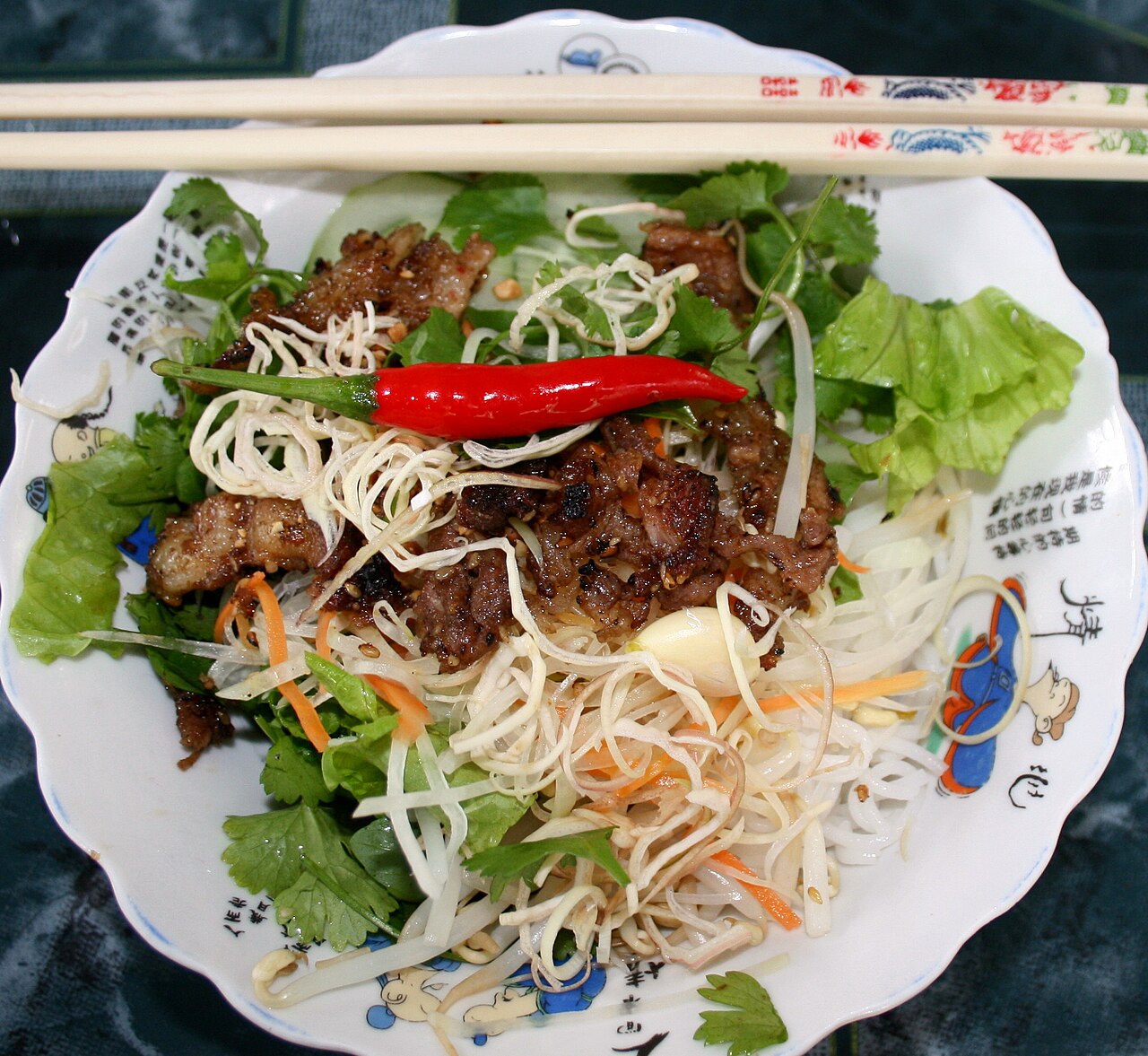 A bowl of Vietnamese noodles topped with tasty grilled pork.