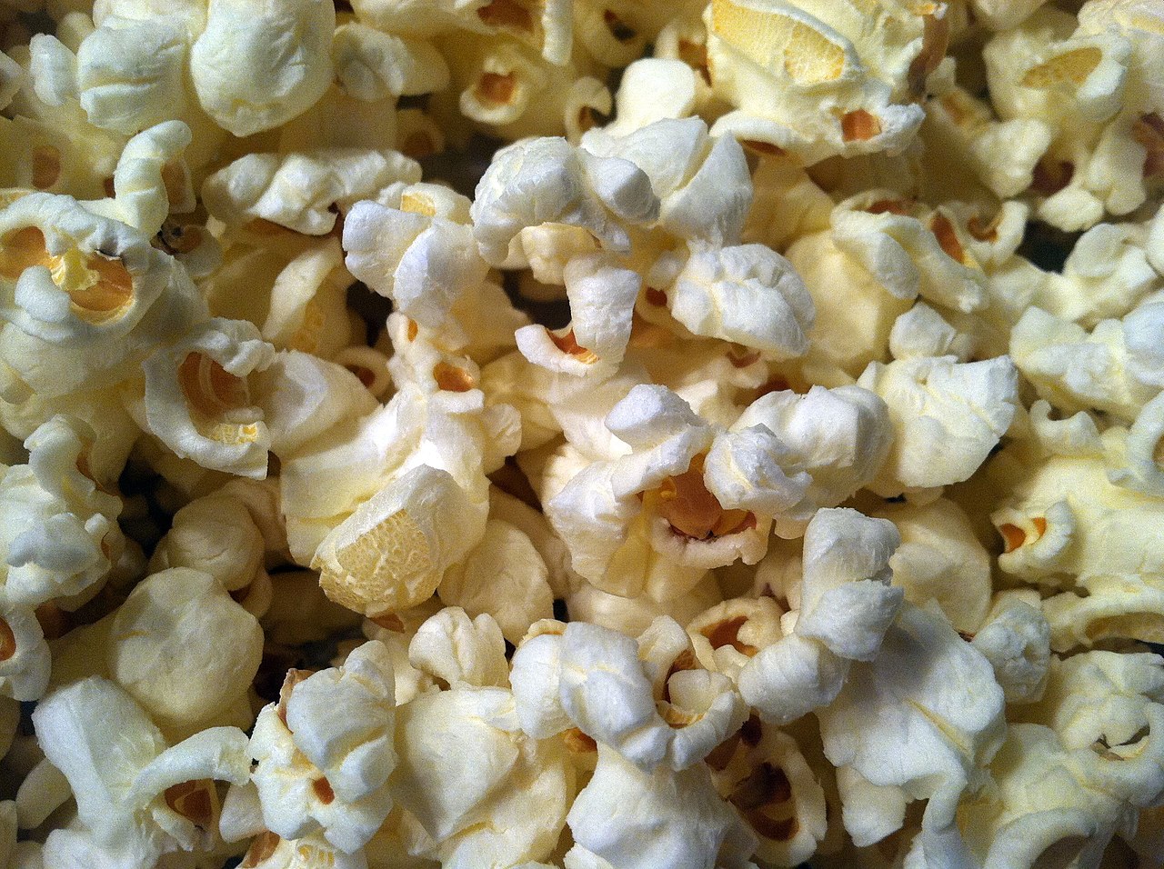 A close-up of fluffy, white popped popcorn kernels.