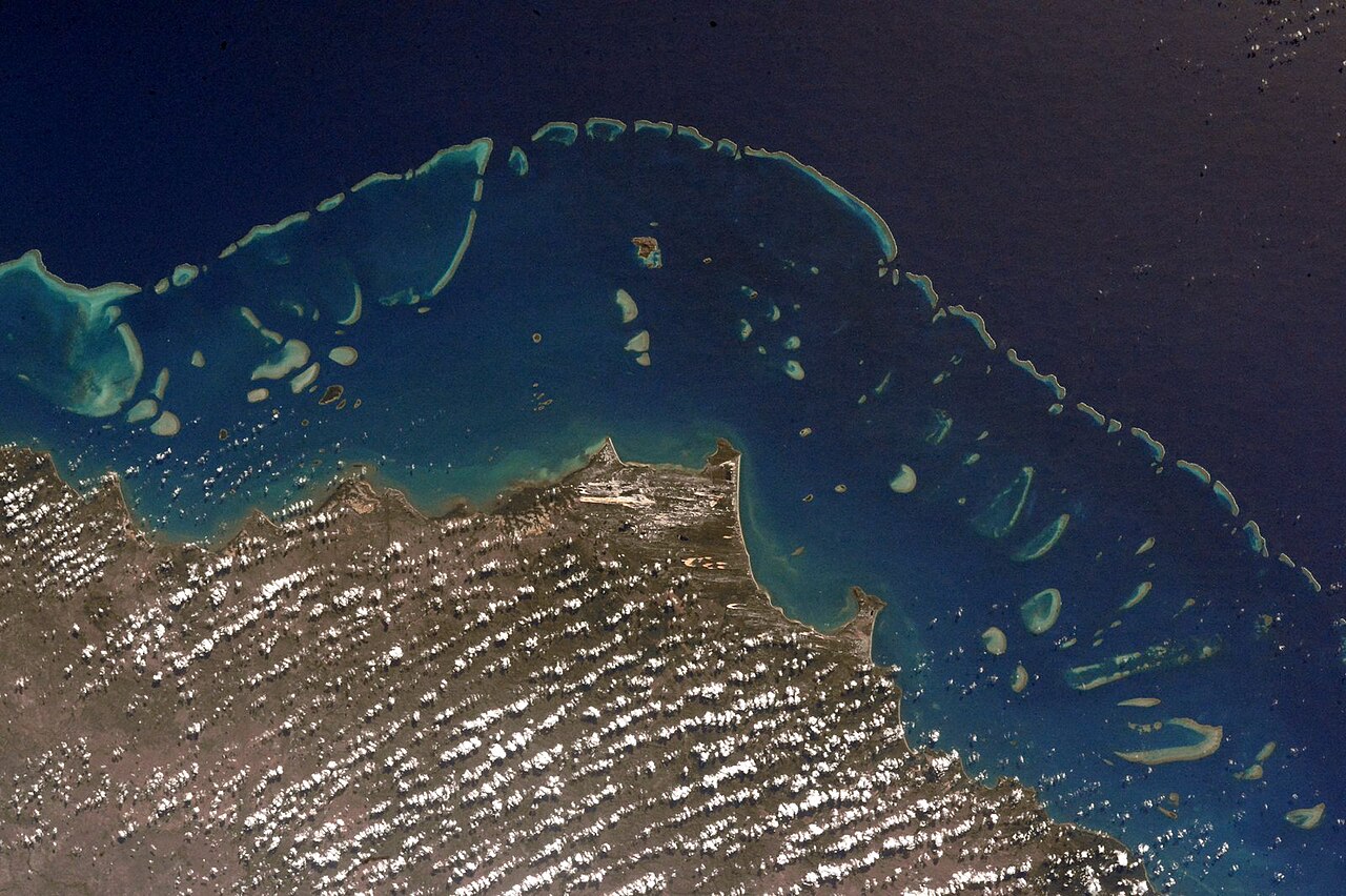 Bright blue reef waters trace the edge of Australia's coast.