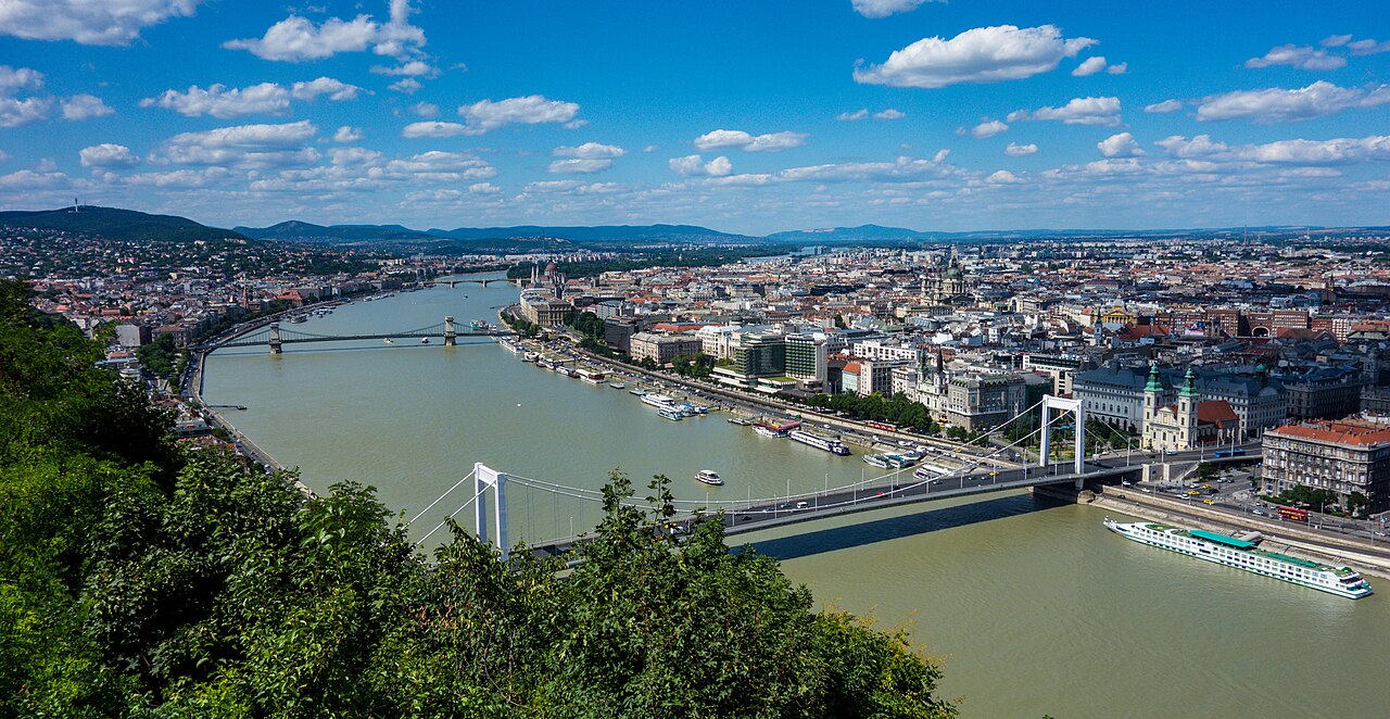 The Danube River flows past a grand city at night.