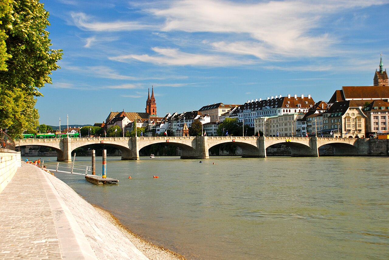 An old stone bridge crosses the wide Rhine River.