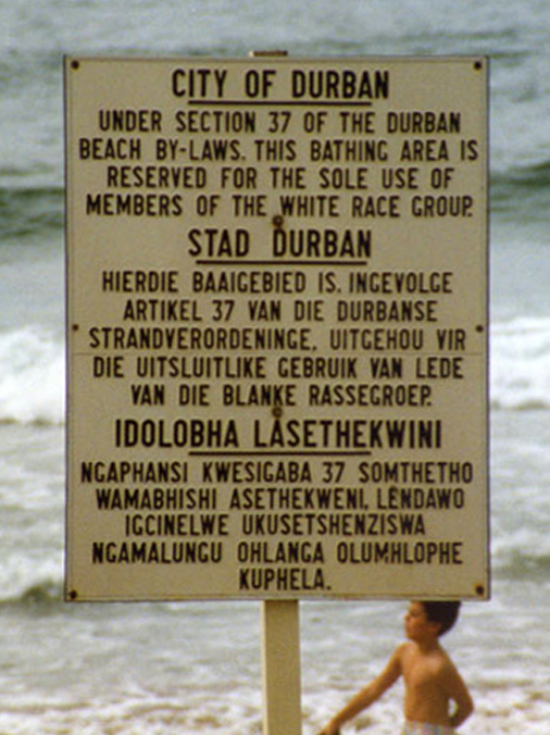 A sad old sign showing unfair rules that kept people apart.
