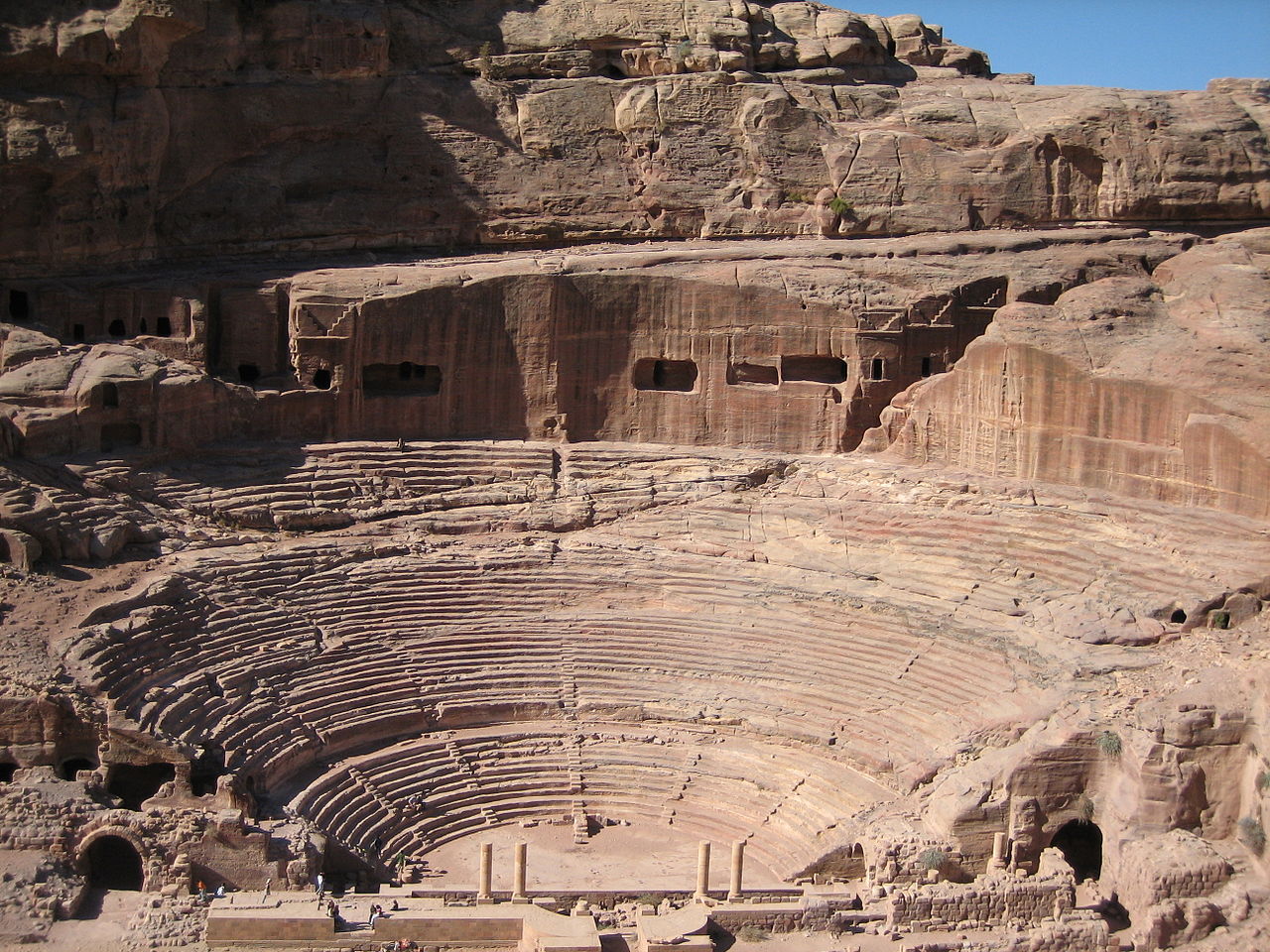 A building carved right into pink stone cliffs in Petra.