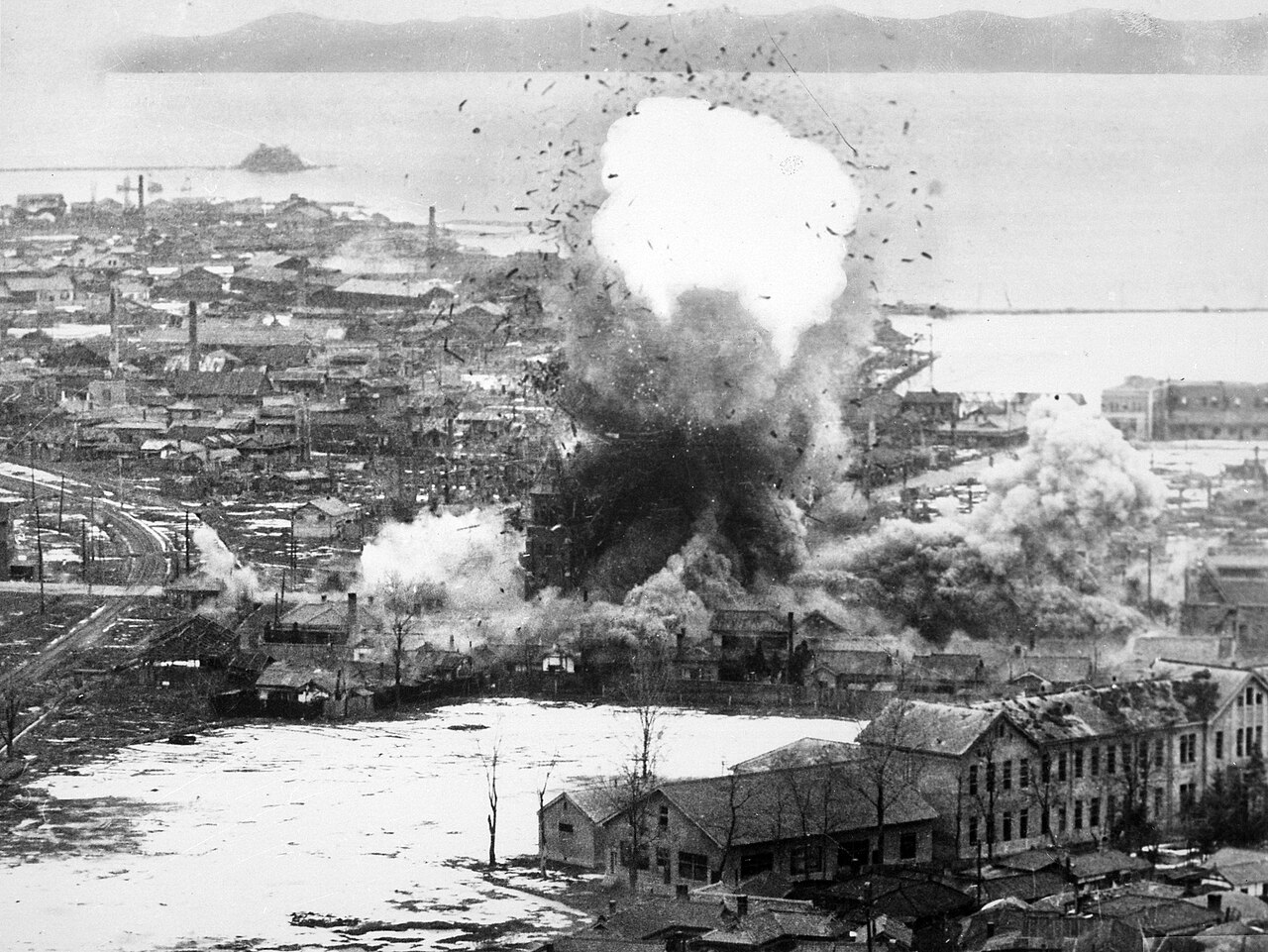 Planes drop bombs on a seaside town during the Korean War.