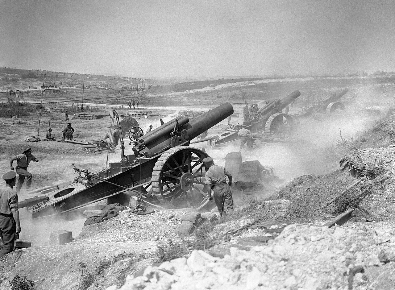 Soldiers fire very large cannons during a battle in World War I.