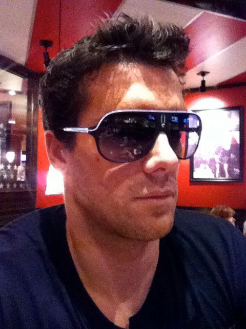 A man wearing cool dark sunglasses outside.
