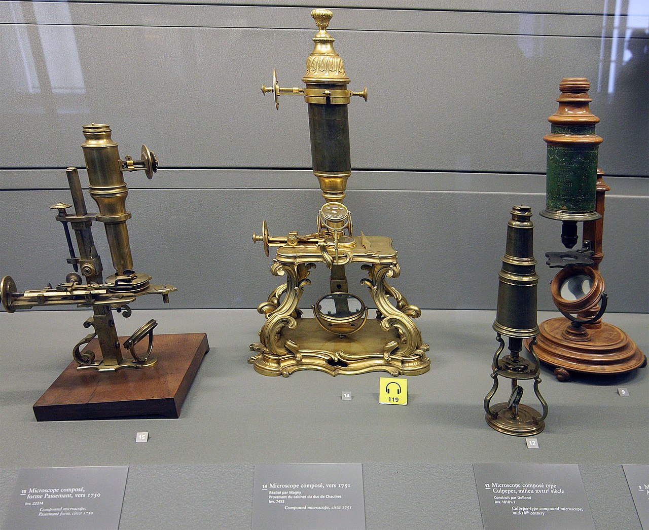 Fancy old microscopes on display inside a museum.