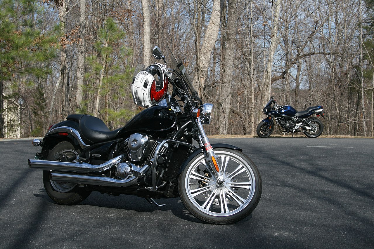 A shiny motorcycle parked with a helmet on top.