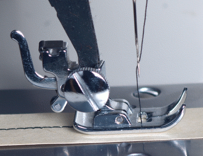 A sewing machine stitching thread into fabric.