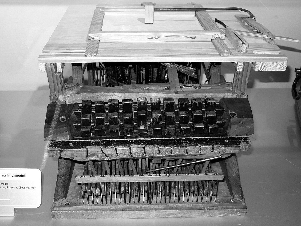 An old wooden typewriter with lots of round keys.