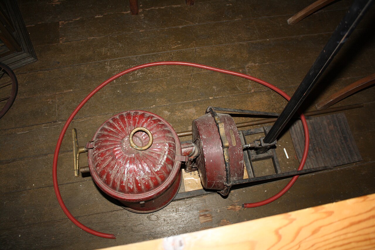 An old-fashioned vacuum cleaner shown in a museum.