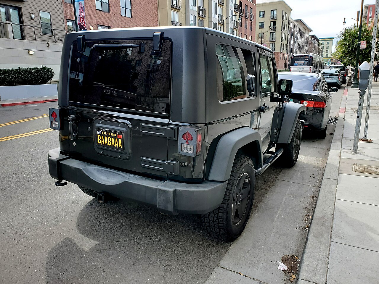 A car with a silly license plate that makes a sheep pun.
