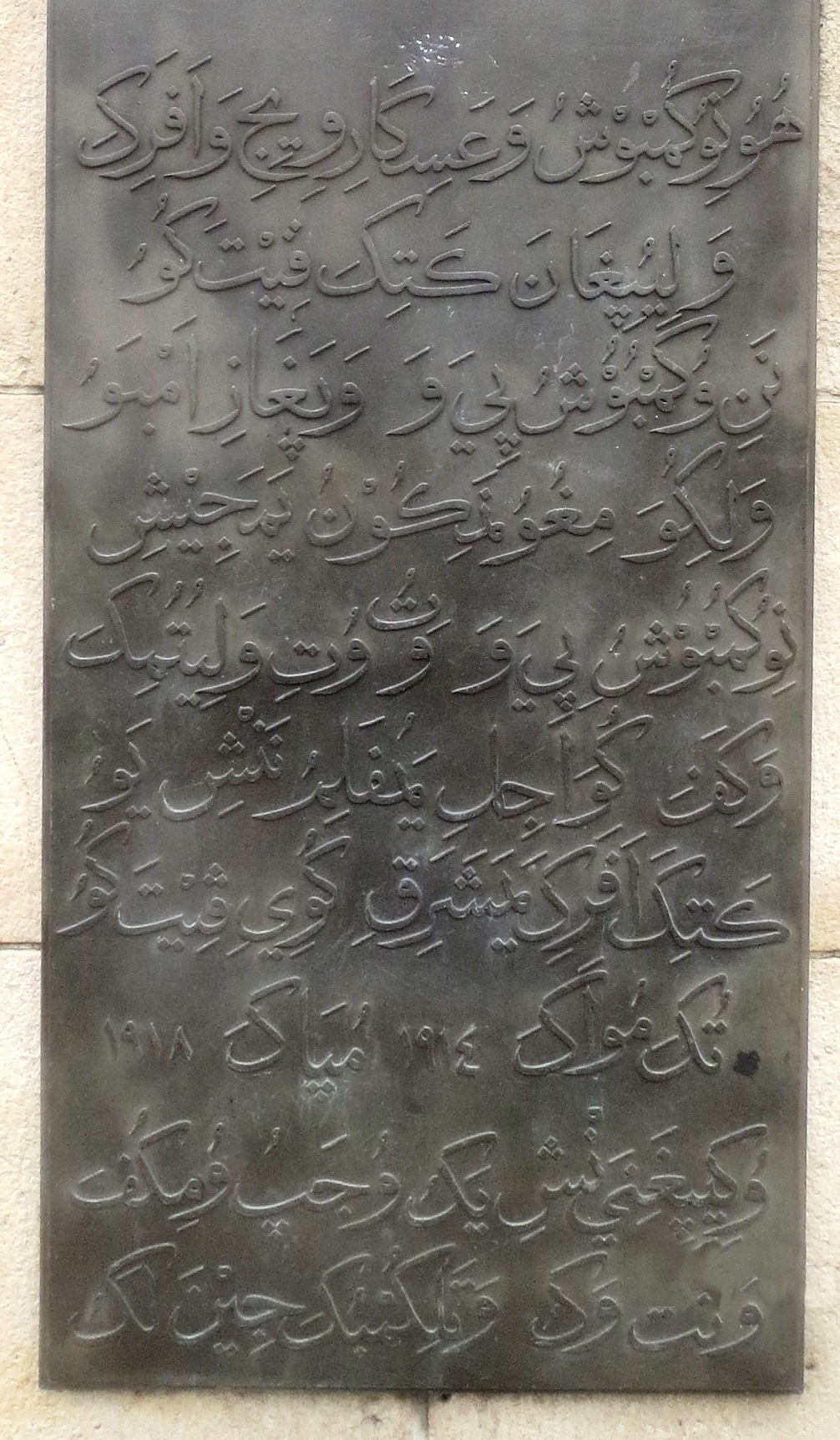 A monument plaque with Swahili writing in Arabic letters.