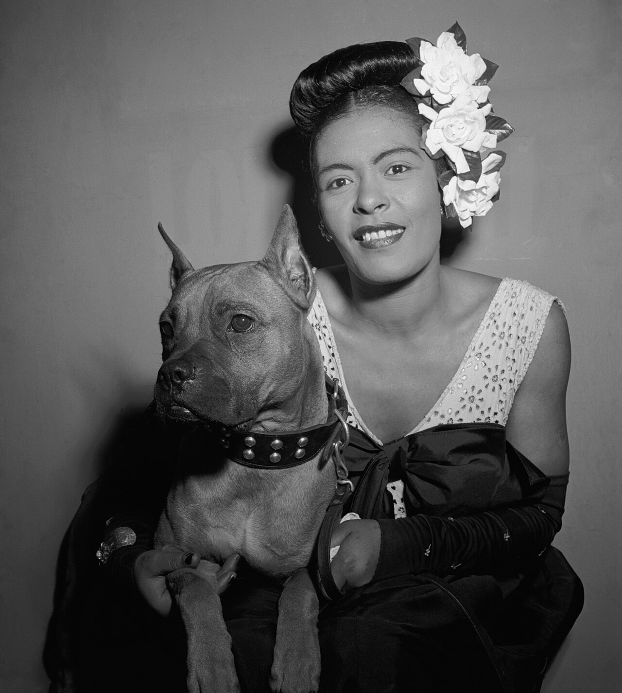 Singer Billie Holiday posing with her little dog in New York.