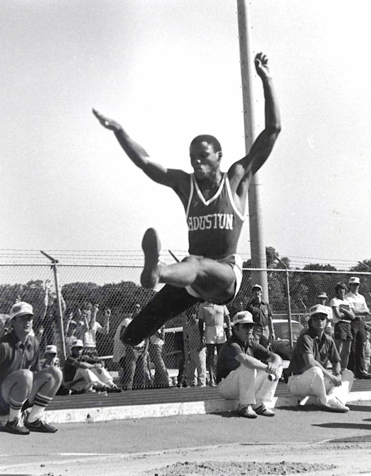 College athlete Carl Lewis in midair during a long jump.