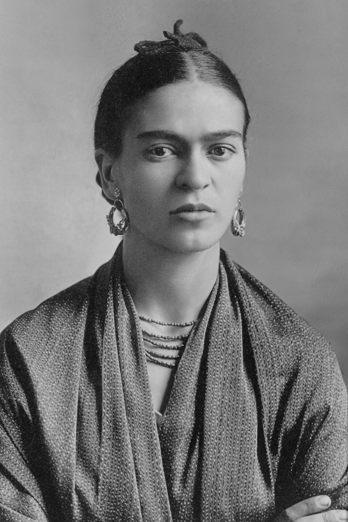 A black and white photograph of the painter Frida Kahlo.