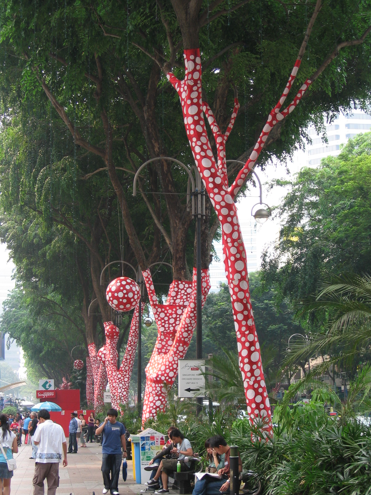A colorful Yayoi Kusama art display on a busy Singapore street.
