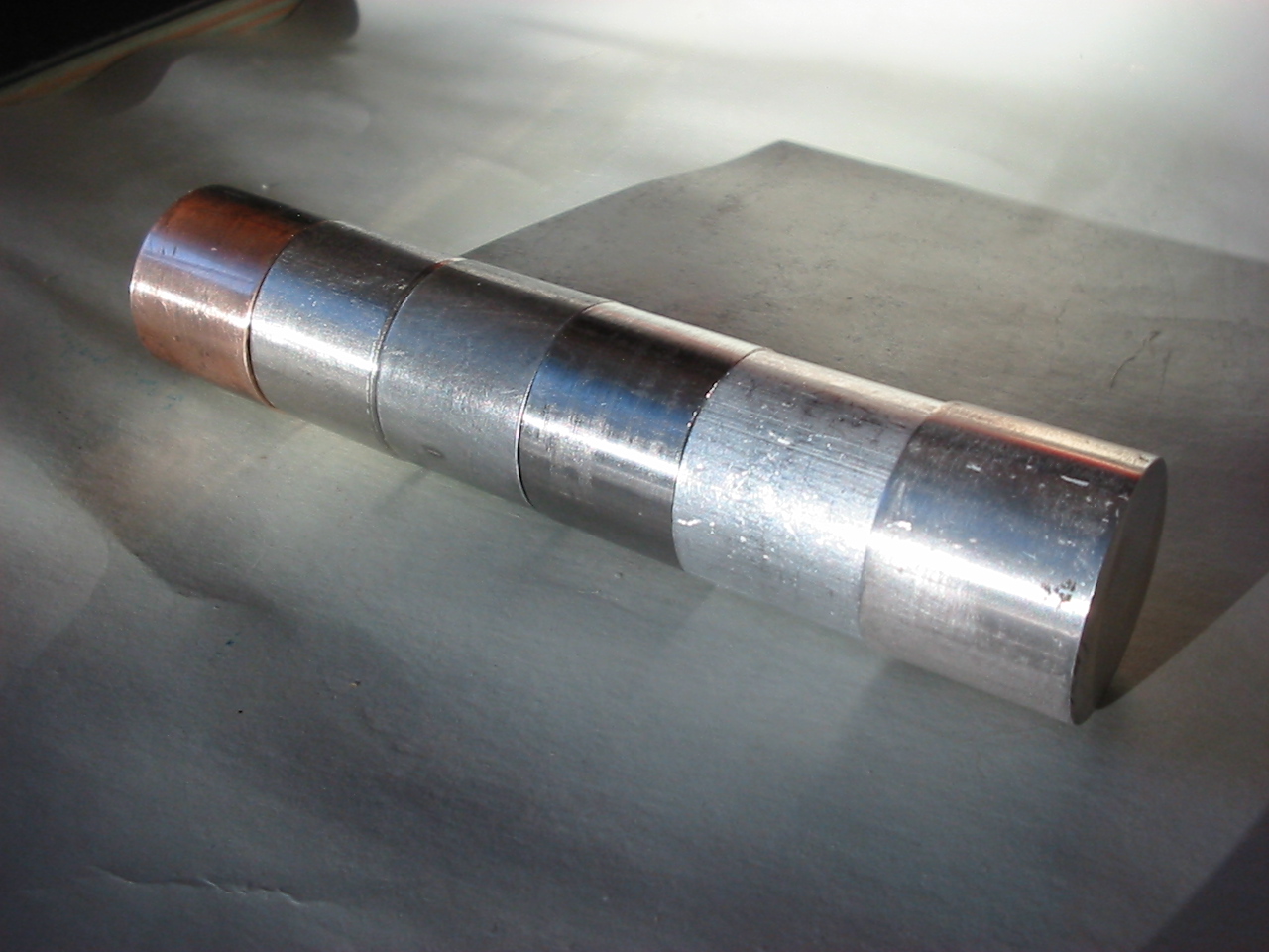 A row of round metal samples showing different alloys and colors.