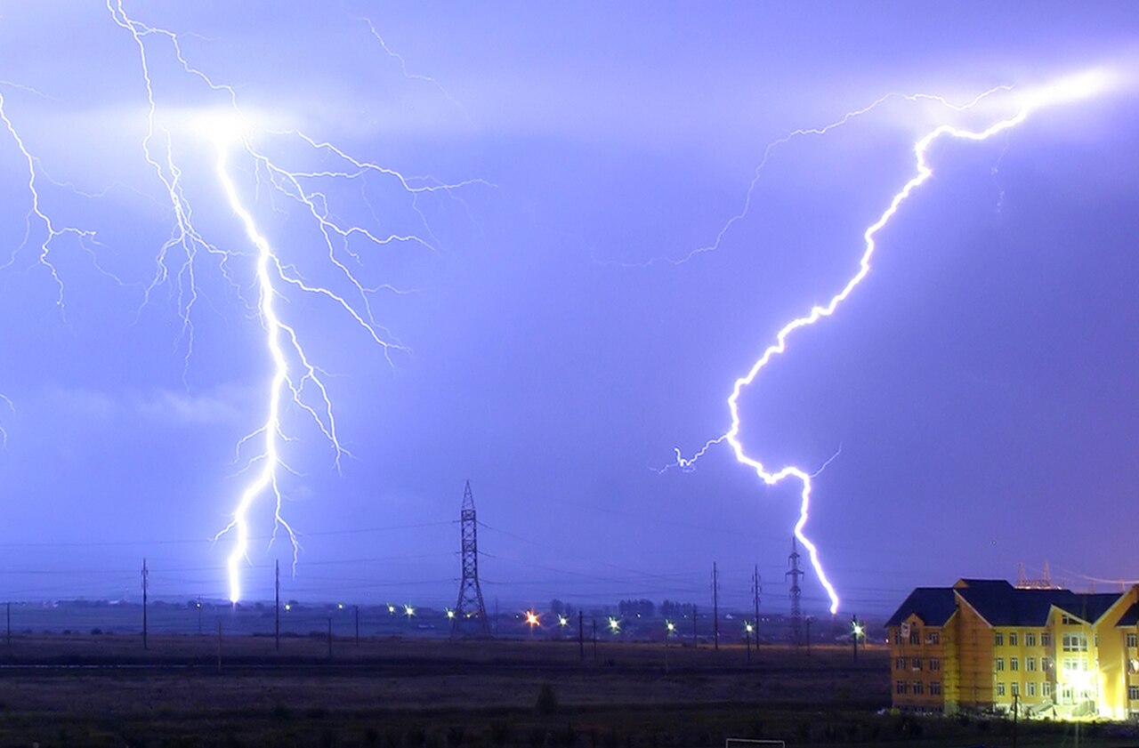 Bright lightning bolts flash across the sky during a big storm.