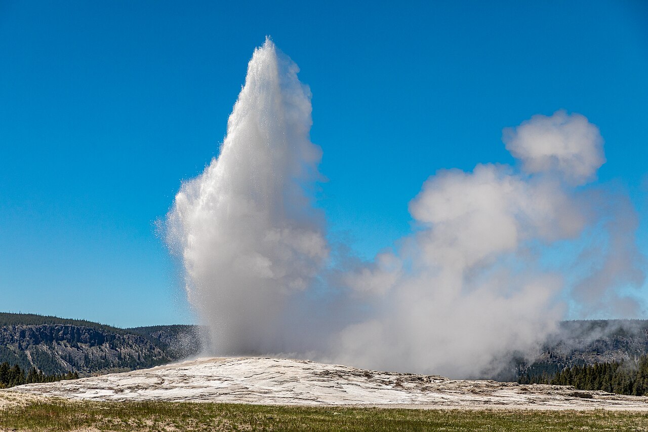 Old Faithful shoots hot water high into the sky at Yellowstone.