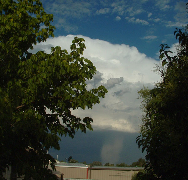 A tall wall of hail falls from a storm cloud.