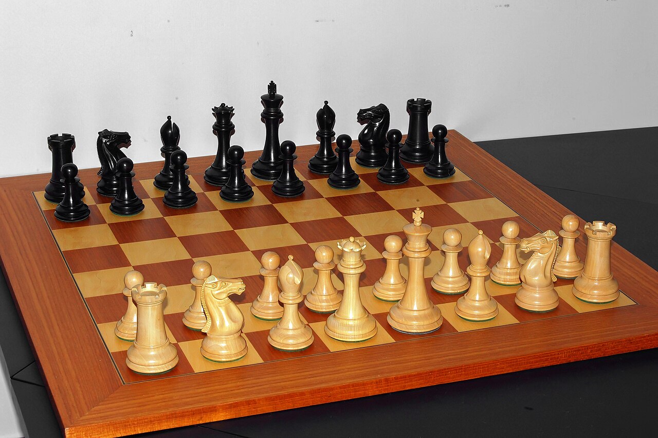 A chess board set up with all the pieces ready to play.