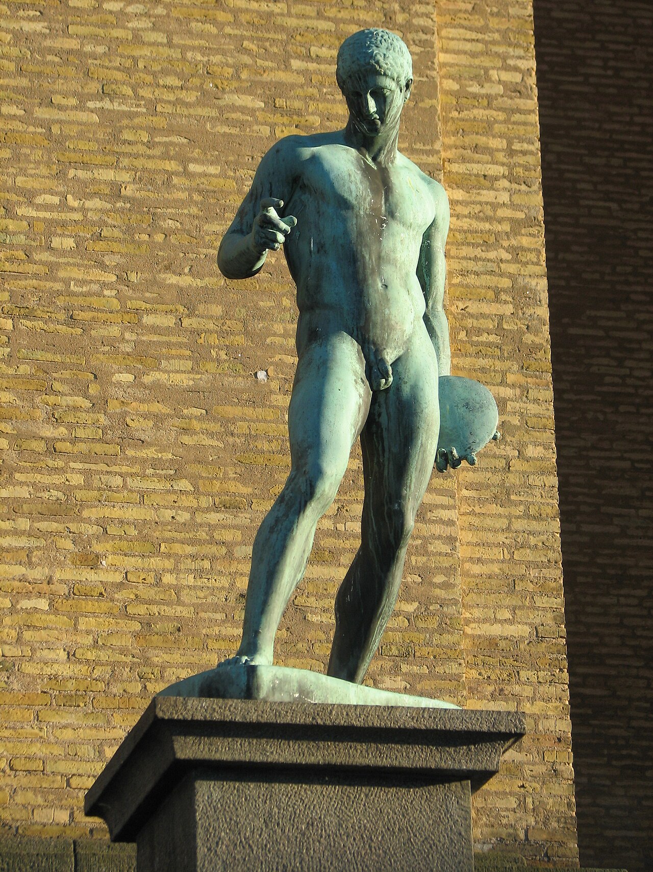 A bronze statue of an athlete twisting to throw the discus.