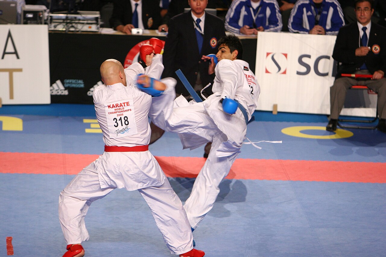 Two karate athletes spar during a big world championship match.