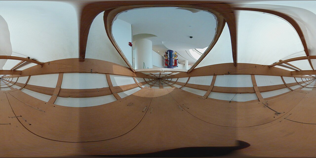 An old kayak made from wood and animal skins, shown inside a museum.