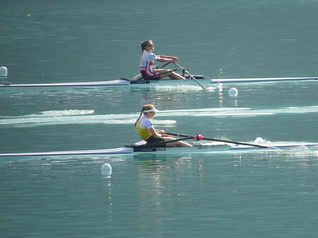 Two rowing teams race their long boats across the water.